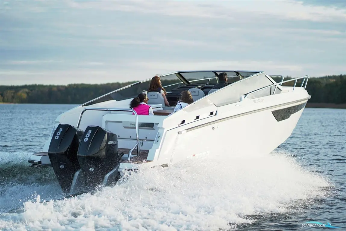 A white motorboat speeds across a lake, with four passengers visible enjoying the ride. Two outboard motors are shown.